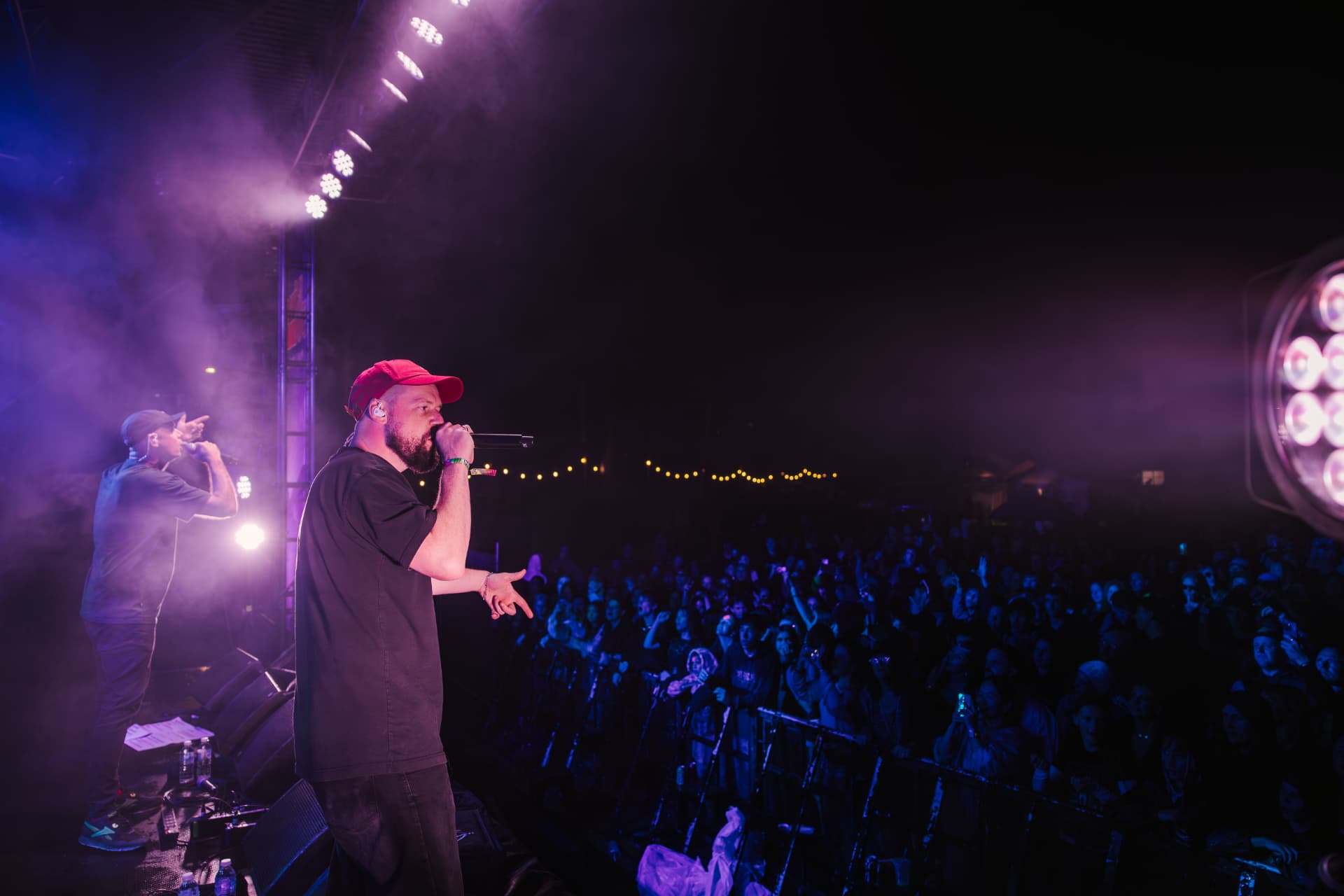 MC performing to a crowd under purple lights