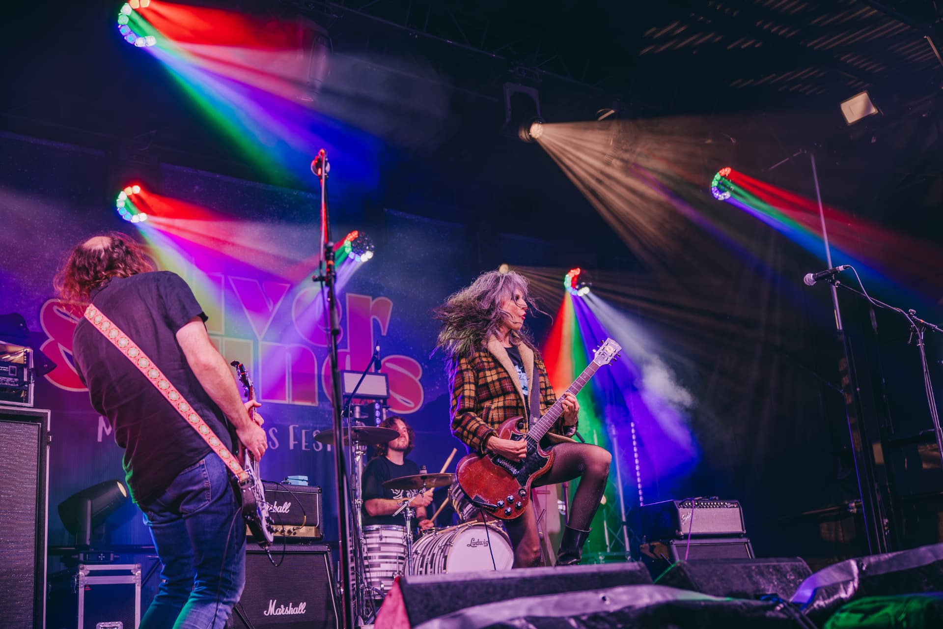 Band playing under rainbow stage lights